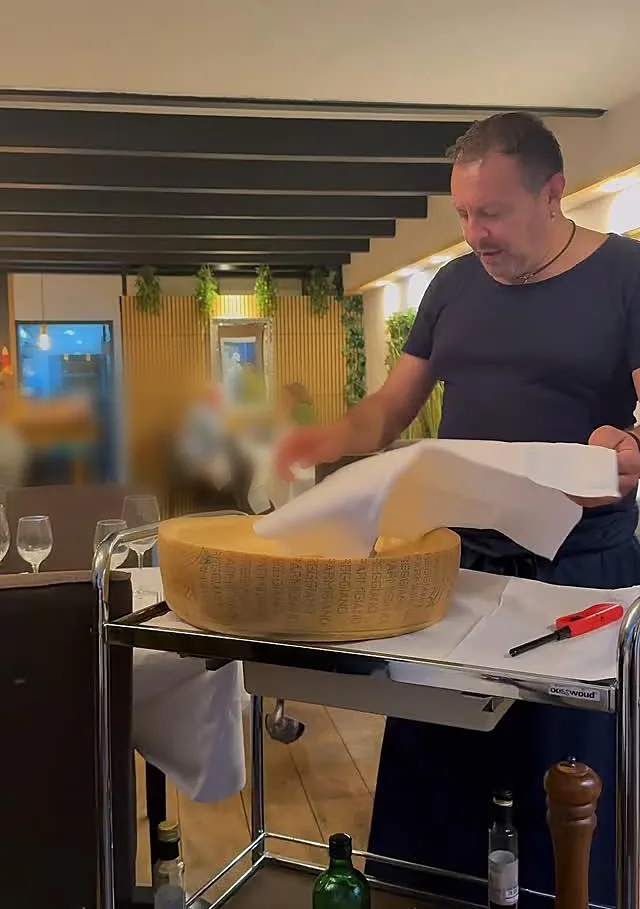 Pietro aan tafel bij het wiel Parmigiano Reggiano